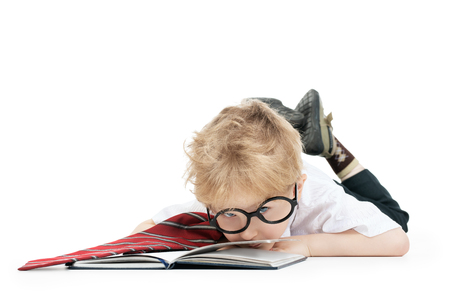 A portrait of a funny tired young schoolboy with a notebook. Kids fashion for school, stationery, education.の写真素材