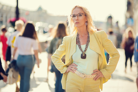 A portrait of an elderly stylish woman walking in the street. Beauty, city fashion.の写真素材