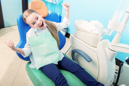 A portrait of a child girl in the cabinet of a dentist. treatment, medicine, hospital.の写真素材