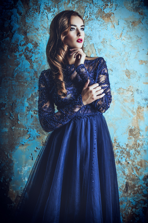 A portrait of a beautiful dark-haired lady in the studio. Evening dress. Fashion, beauty.の写真素材