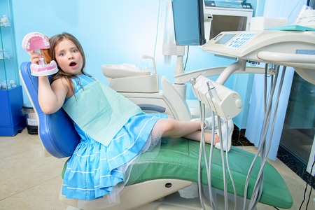 A portrait of a child girl in the cabinet of a dentist. treatment, medicine, hospital.の写真素材