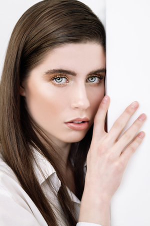 A close up portrait of a beautiful dark-haired young woman posing over the white background. Beauty, cosmetics.の写真素材