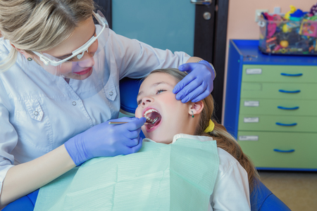A cabinet of a dentist. Treatment, medicine, hospital. A girl curing teeth.の写真素材