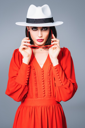 A portrait of a beautiful woman wearing a hat and sunglasses. Fashion, style, beauty, optics.の写真素材