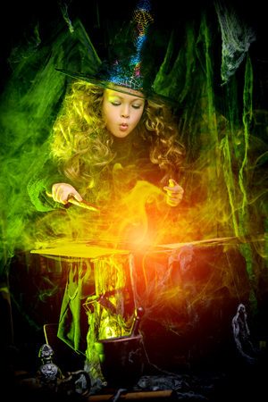Happy Halloween. Cute little witch casts a spell on a secret book.の写真素材