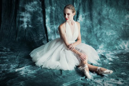 A full length portrait of an elegant refined female ballet dancer posing in the studio over the grunge background. Talent, fashion for ballet dancers.の写真素材