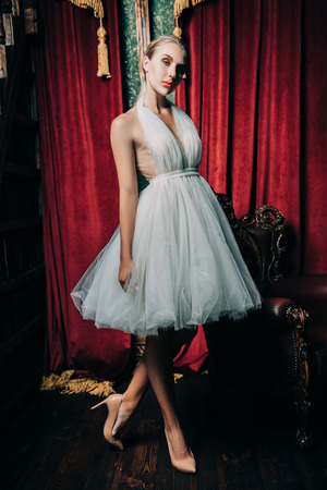 A full length portrait of an elegant refined female ballet dancer posing in the vintage interior. Talent, fashion for ballet dancers.の写真素材