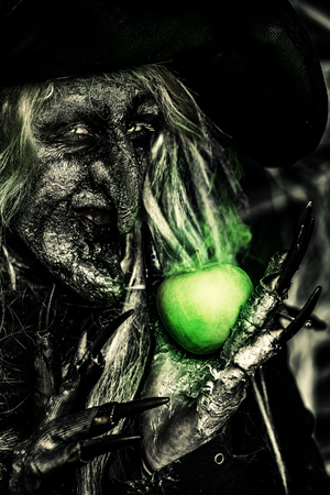 A witch holding an apple. Halloween. Horror movie.の写真素材