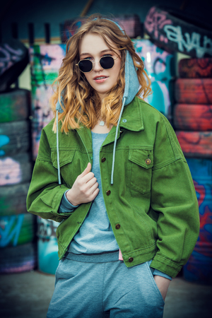 Modern young woman in casual youth clothes over urban background. Beauty, city fashion.の写真素材