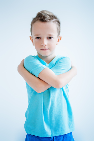 A portrait of a handsome child boy posing in the studio over the blue background. Kids, fashion, casual style, beauty.の写真素材