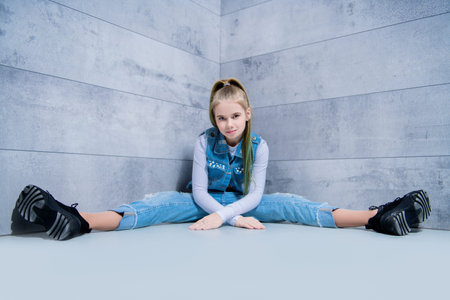 A full length portrait of a young girl posing in the corner in the studio. Beauty, fashion.の写真素材