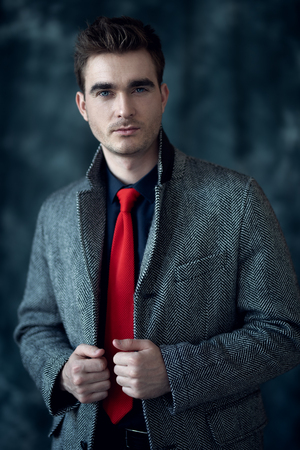 A portrait of a fashionable young man posing in the studio over the grey background. Casual fashion for men.の写真素材