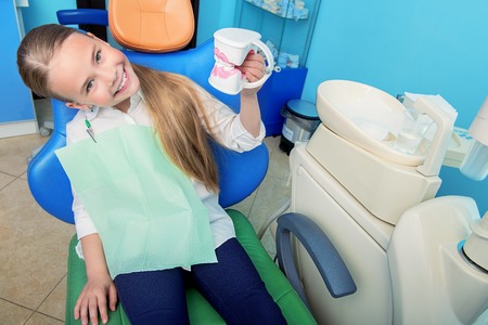 A portrait of a child girl in the cabinet of a dentist. treatment, medicine, hospital.の写真素材