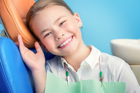 A portrait of a child girl in the cabinet of a dentist. treatment, medicine, hospital.の写真素材