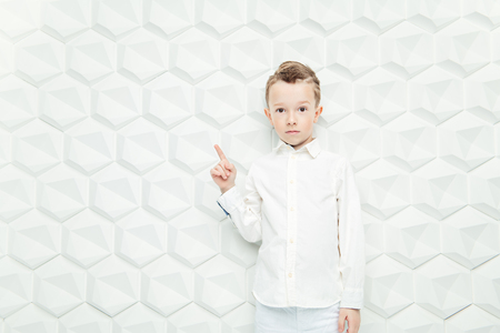 A portrait of a modern fashionable child boy posing in the studio over the white background. Kids, fashion, style, beauty.の写真素材