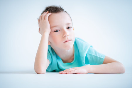 A portrait of a handsome child boy posing in the studio over the white background. Kids, fashion,...