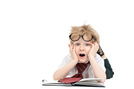 A portrait of a funny tired young schoolboy with a notebook. Kids fashion for school, stationery, education.の写真素材