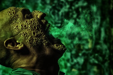 A close up portrait of a sick scientist after a failed experiment in the green light. Desperation, hopelessness. Horror, halloween.の写真素材