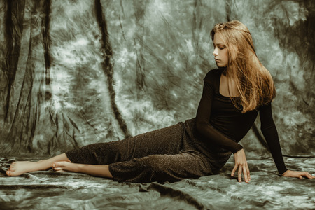 A full length portrait of a thoughtful young woman posing indoor. Beauty, fashion.の写真素材