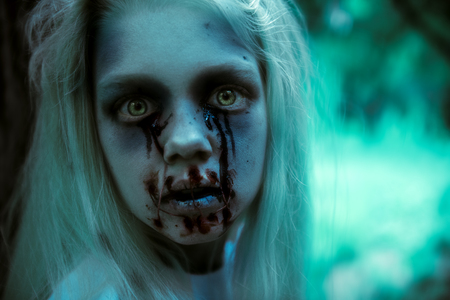 A close up portrait of a scary pale girl from horror film. Zombie, halloween.の写真素材