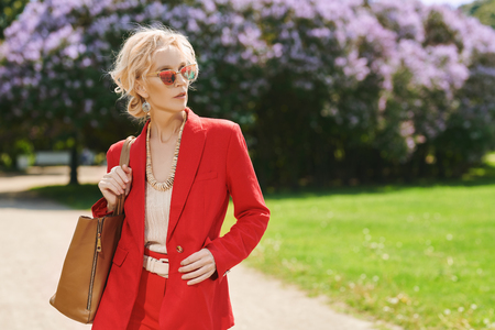 A portrait of an elderly stylish woman in the summer park. Beauty, fashion.の写真素材