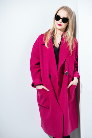 A portrait of a fashionable young lady posing in the studio over the white background. Beauty, fashion, style.の写真素材