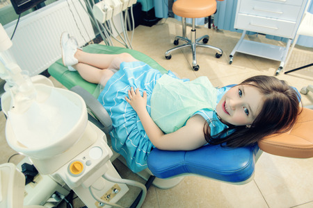A portrait of a child girl in the cabinet of a dentist. treatment, medicine, hospital.の写真素材