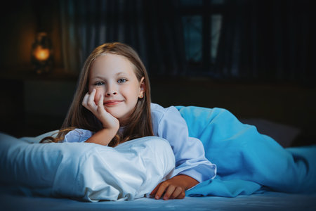 A portrait of a young pretty smiling girl in bed. Relax, pajamas.