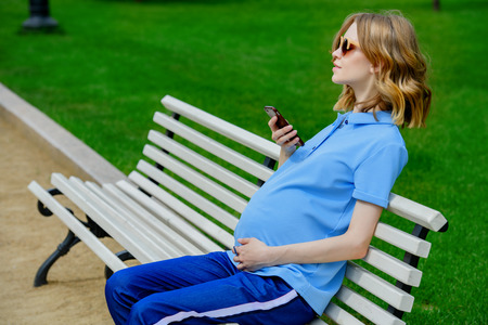 Pregnant young woman is walking in the park. Pregnancy and motherhood. Healthy lifestyle.の写真素材
