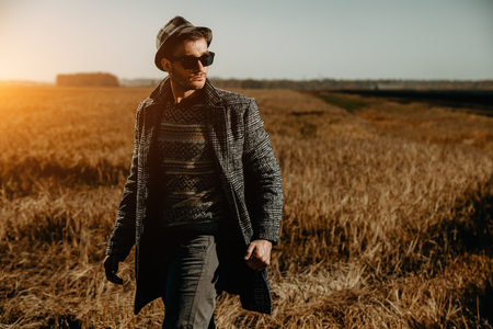 A portrait of a handsome man in countryside. Autumn fashion for men. Freedom, lifestyle.の写真素材