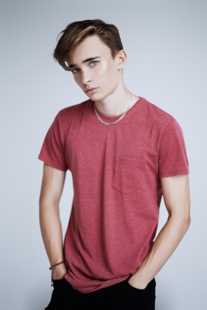 A portrait of a young goodlooking guy in a red t-shirt. Beauty of men, casual fashion.の写真素材