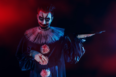 A portrait of an angry crazy clown from a horror film with a platter. Halloween, carnival.の写真素材