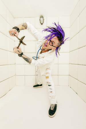 Portrait of a cheerful crazy doctor with scissors in a psychiatric hospital.の写真素材