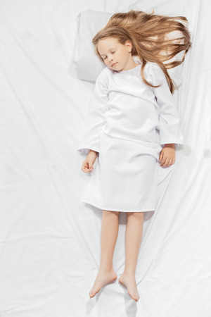 A portrait of a young pretty sleeping girl in bed. Relax, pajamas.の写真素材