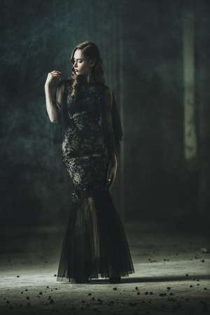 A beautiful brunette lady is in ruins. Evening dress. Fashion, beauty.の写真素材