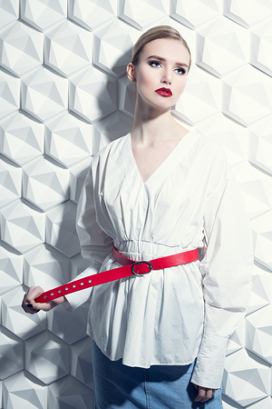 A portrait of a confident lady wearing a white blouse and posing in the studio over the white background. Beauty, make-up, style.の写真素材