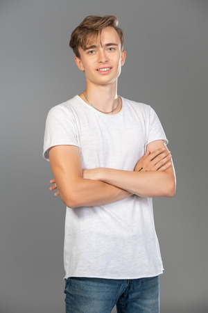 A portrait of a young goodlooking guy in a white t-shirt. Beauty of men, casual fashion.の写真素材