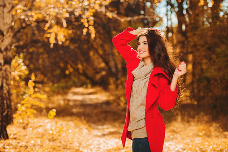 A portrait of a beautiful young woman in an autumn forest. Lifestyle, autumn fashion, beauty.の写真素材