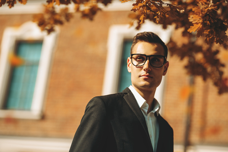 A portrait of a goodlooking young guy walking in the street. Men's beauty, fashion.の写真素材