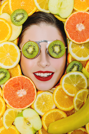 A portrait of a bright beautiful girl with juicy fruit posing in the studio over the yellow background. Beauty, health.の写真素材