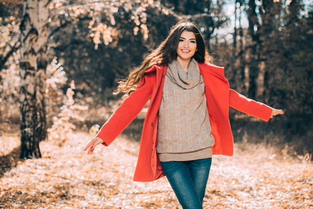 A portrait of a beautiful young woman in an autumn forest. Lifestyle, autumn fashion, beauty.の写真素材