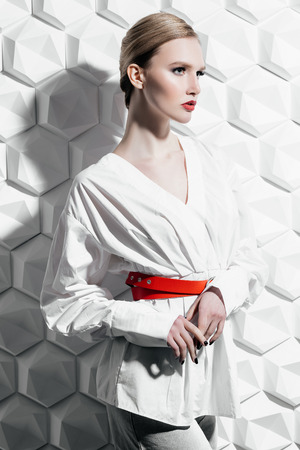 A portrait of a confident lady wearing a white blouse and posing in the studio over the white background. Beauty, make-up, style.の写真素材