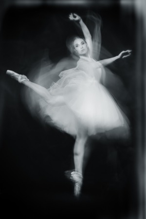 A full length portrait of a refined female ballet dancer posing in the studio over the black background. Talent, fashion for ballet dancers.の写真素材