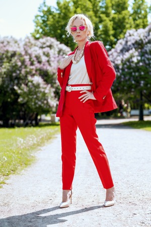 A full length portrait of an elderly stylish woman in the summer park. Beauty, fashion.の写真素材