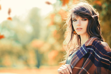 A close up portrait of a young woman in the park. Beauty, cosmetics, skin protection.