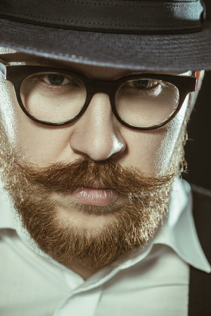 A close up portrait of a thoughtful man posing in the studio over the black background. Men's beauty, fashion, style.の写真素材