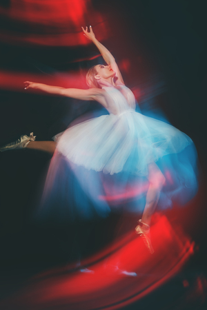 A full length portrait of a refined female ballet dancer posing in the studio over the black background. Talent, fashion for ballet dancers.の写真素材