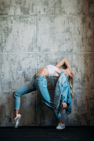 A full length portrait of an active sporty young lady posing in the studio. Beauty, casual fashion.の写真素材