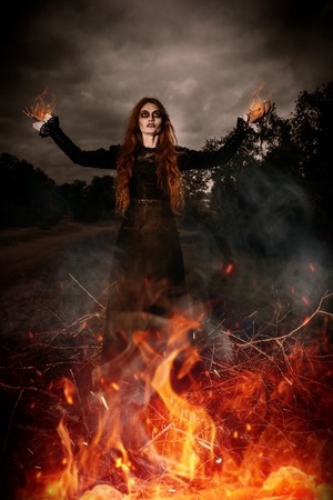 A portrait of an angry witch near the fire. Magic, dark force, spell.の写真素材
