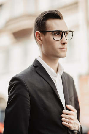 A portrait of a goodlooking young guy walking in the street. Men's beauty, fashion.の写真素材